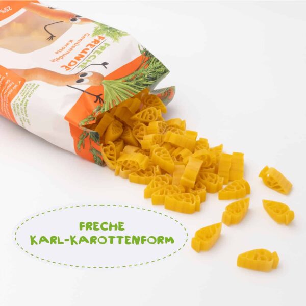 Freche Freunde Bio Gemüsenudeln Karotte – der geöffnete Beutel kippt eine bunte Portion freche Nudeln in Karl-Karottenform auf den Tisch. Der freche Look sorgt für Spaß auf dem Teller!