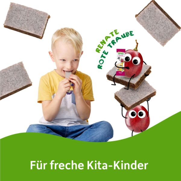 Ein blondes Kind sitzt fröhlich und beißt in einen frechen Freche Freunde Riegel Rote Traube, Banane & Aronia. Daneben stapeln sich die quadratischen Riegelscheiben, auf denen Renate Rote Traube mit wackeligen Ärmchen sitzt und das Produkt präsentiert. Text: "Für freche Kita-Kinder".