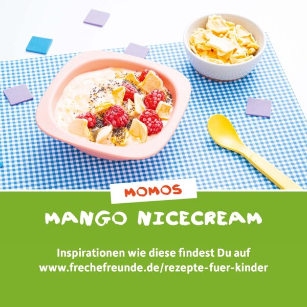 Rezept: Eine sommerliche Bowl mit Mango-Nicecream, getoppt mit Himbeeren, Chia-Samen und knusprigen Mangochips. Daneben steht eine Schale mit weiteren Chips und ein gelber Kinderlöffel. Momo Mango lädt zum Ausprobieren ein. Text: „Momos Mango Nicecream – Inspirationen wie diese findest du auf frechefreunde.de“.