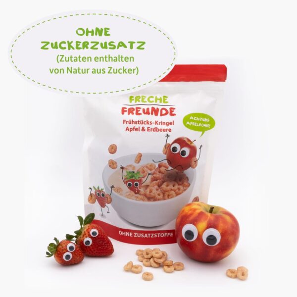 Freche Freunde Bio Frühstücks-Kringel Apfel & Erdbeere umgeben von den Charakteren Alfred Apfel und Edda Erdbeere mit Kulleraugen. Daneben liegen echte Früchte mit Wackelaugen. Text: „Ohne Zuckerzusatz“.