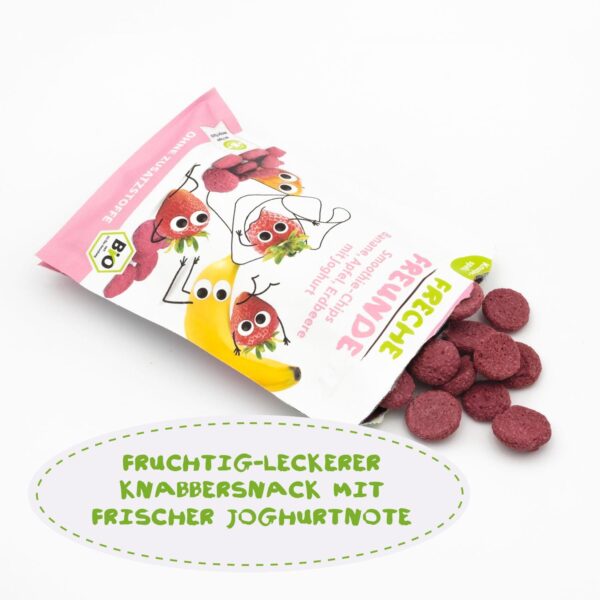 Geöffneter Beutel der Freche Freunde Bio Smoothie-Chips mit herausfallenden, pinken Knusperchips. Sichtbar sind die lachenden Fruchtcharaktere auf der Verpackung. Text: Fruchtig-Leckerer Knabbersnack mit frischer Joghurtnote.