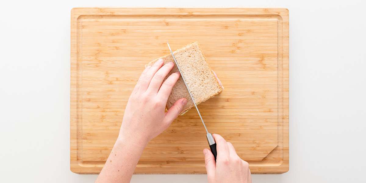 Das Gemüse-Sandwich wird mit einem Messer in der Mitte geschnitten.