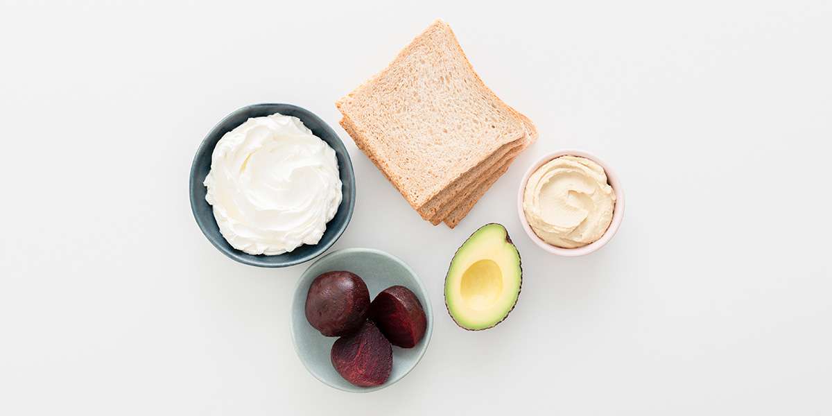 Frischkäse, Brotscheiben, Hummus, Rote Bete und Avocado für's Gemüse-Sandwich