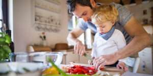 Freche Freunde - Blogbeitrag 10 Tipps fürs Kochen mit Kindern - Papa zeigt dem Kind, wie man eine Paprika schneidet