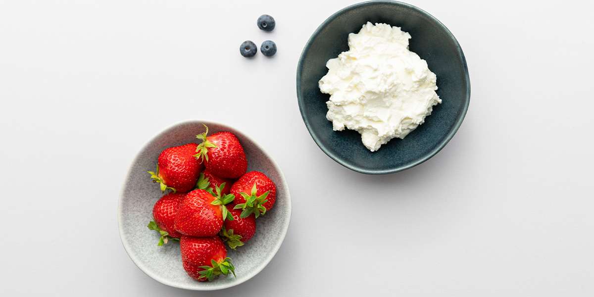 In einer Schüssel Erdbeeren, in der anderen Schüssel Quark für die Erdbeer Zwerge