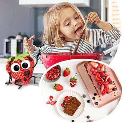 Kuchen für Kinder backen macht Spaß! Das Mädchen schleckt den Teig vom Löffel ab und Edda Erdbeere hat den Teig am ganzen Körper.