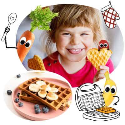 Freche Freunde - Blogbeitrag Waffeln für Kinder - Mädchen steckt frech die Zunge raus und hält Waffeln in Herzform hoch. Karl Karotte und Bob Banane freuen sich, die Waffeln zu backen. Unten rechts sind 2 leckeraussehende Waffeln mit Bananen und Blaubeeren.
