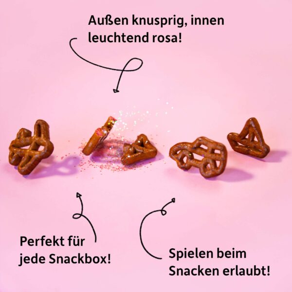 Freche Freunde Bio Laugensnack Rote Bete – Nahaufnahme der kleinen, spielerischen Brezeln in Auto-, Schiff- und Flugzeugform mit rosafarbenem Crunch im Inneren. Dazu Botschaften wie „Spielen beim Snacken erlaubt“ und Perfekt für jede Snackbox.