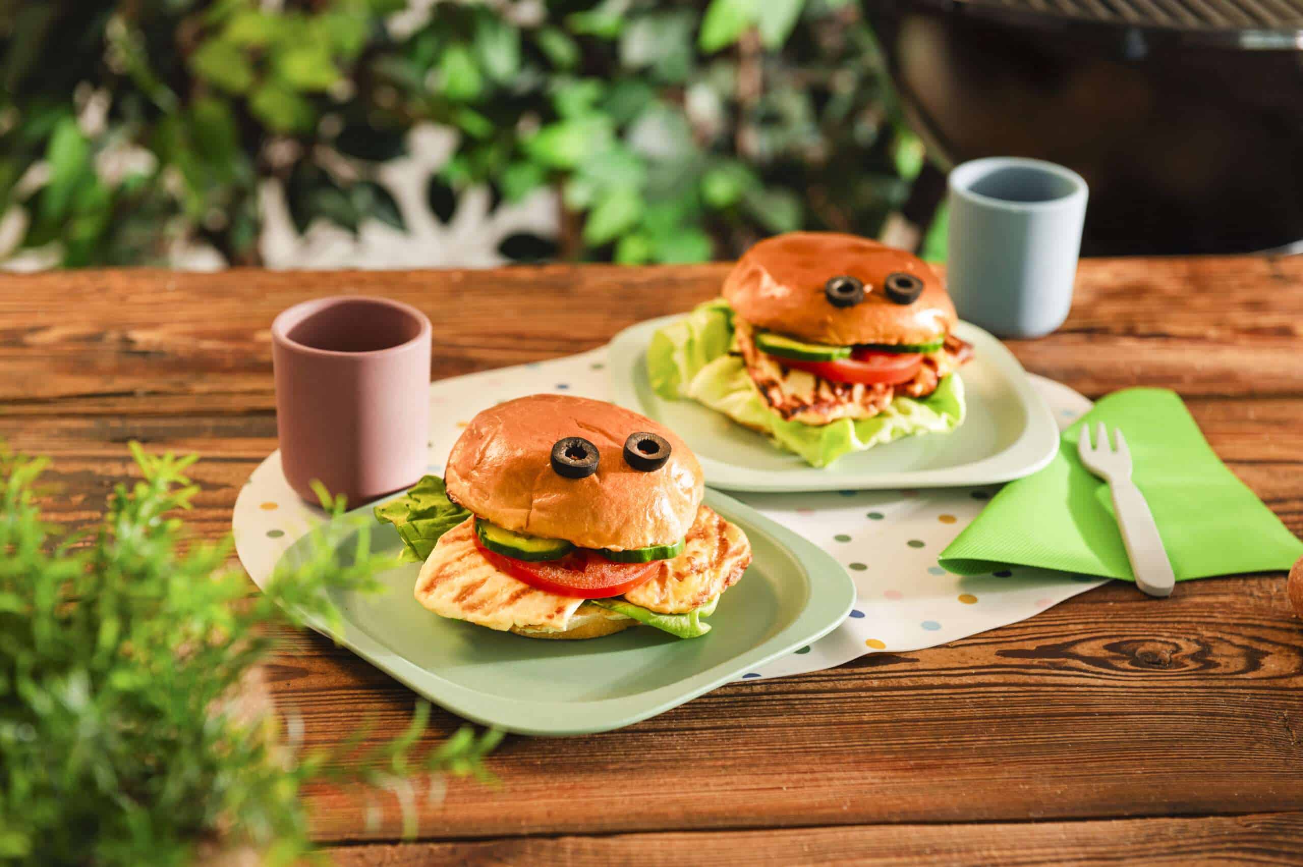 Halloumi Burger auf Teller mit zwei Olivenscheiben als Augen