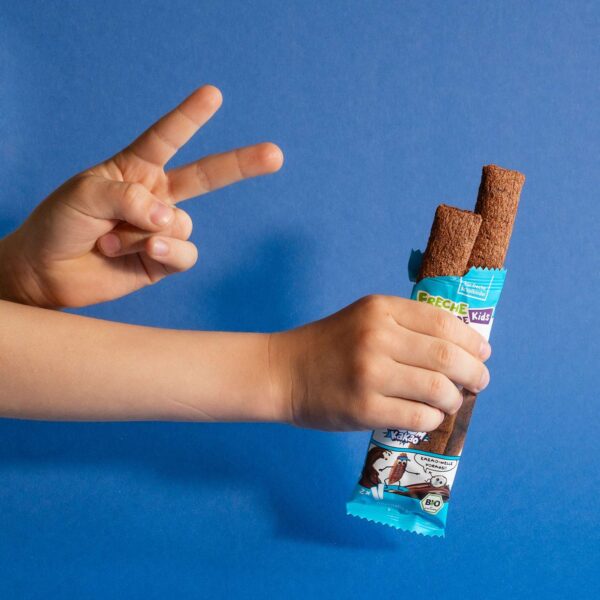 Kinderhand hält zwei Freche Freunde Crunchy Sticks mit Kakaofüllung – ein leckerer Schulhof-Snack für unterwegs.