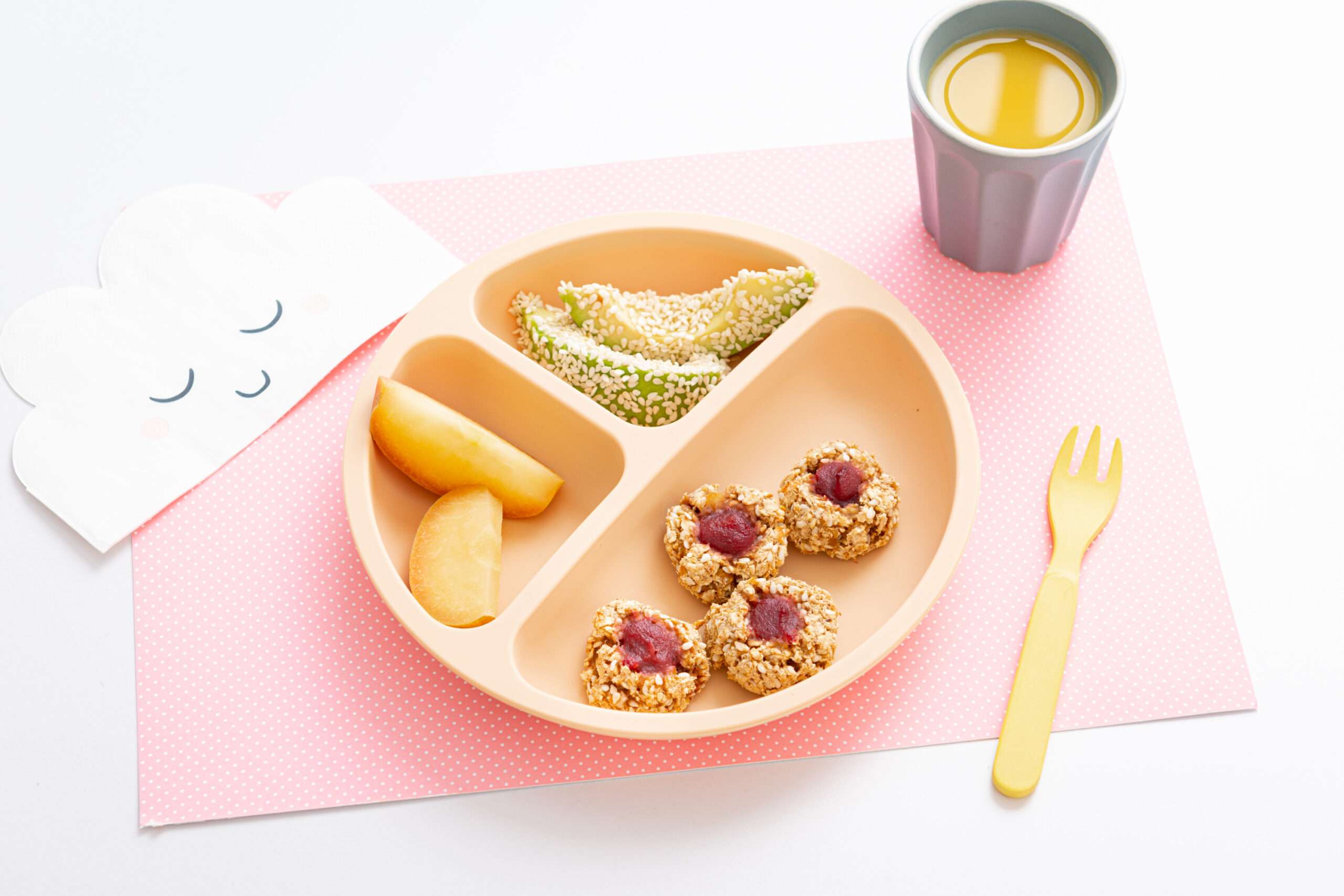 Haferkekse ohne Zucker mit Apfel- & Avocadospalten auf einem Teller mit einen Glas Orangensaftschorle