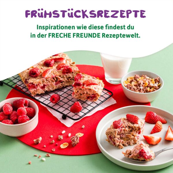 Rezept-Inspiration aus der Freche-Freunde-Rezeptwelt: Selbstgemachte fruchtige Frühstücksschnitten mit frischen Beeren, serviert auf bunten Tellern mit Müsli, Himbeeren und einem Glas Milch