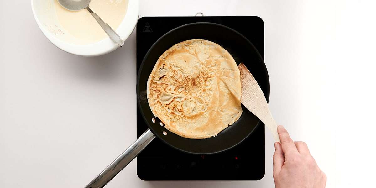 Dinkel Pfannkuchen wird frisch in der Pfanne gebacken 